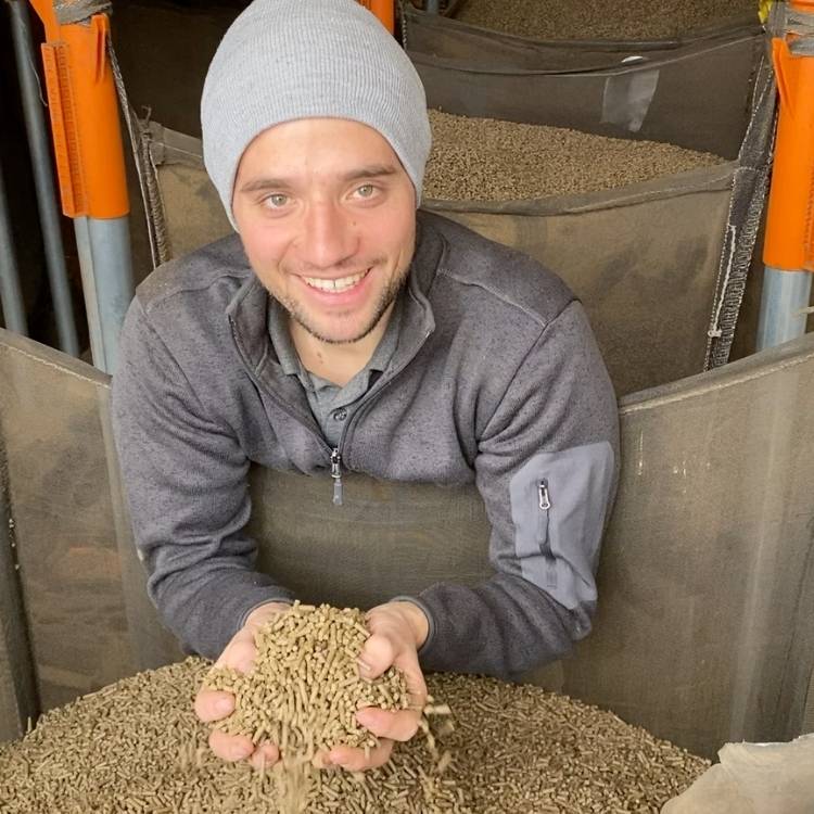 Johann Falter hält Schafwolldünger-Pellets in den Händen.